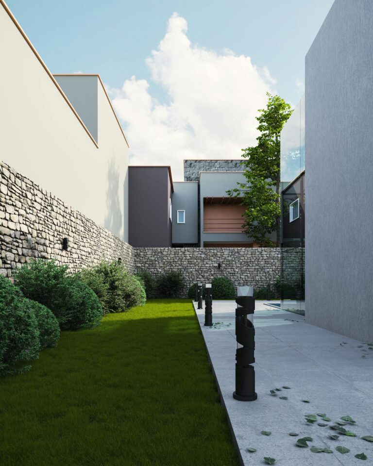 Contemporary courtyard featuring grass and stone walls in urban setting.